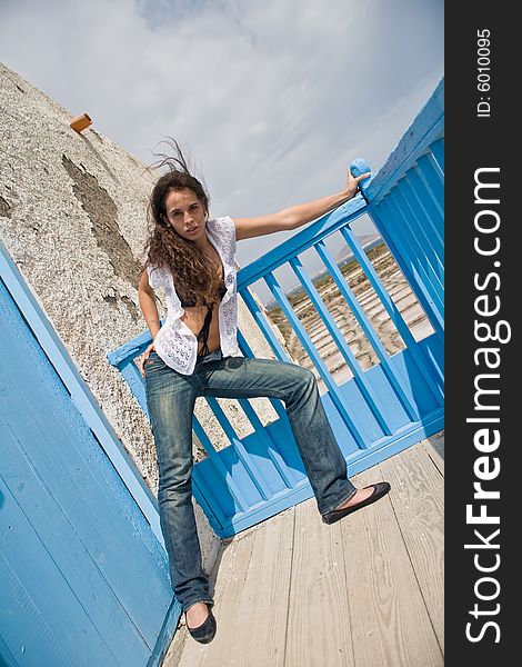 Young attractive woman posing on old house with blue door. Young attractive woman posing on old house with blue door