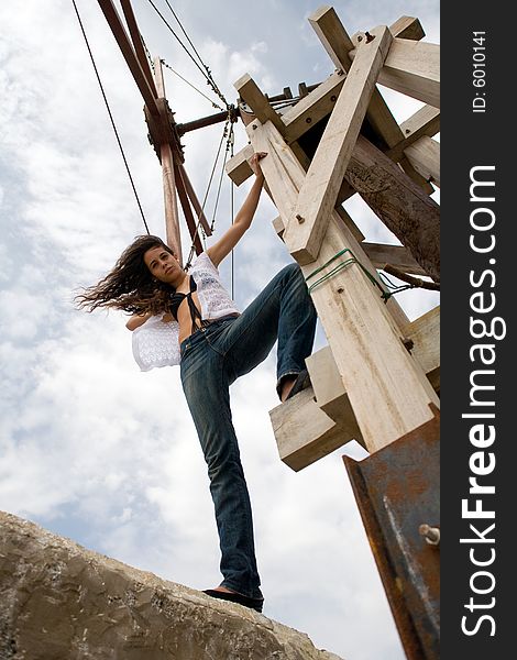 Young attractive woman posing on old windmill. Young attractive woman posing on old windmill