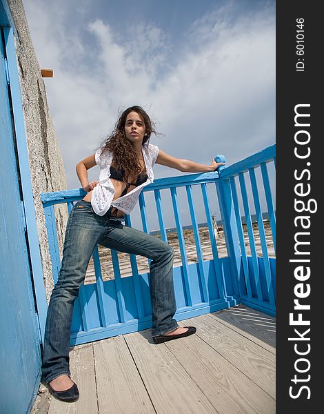 Young attractive woman posing on old house with blue door. Young attractive woman posing on old house with blue door