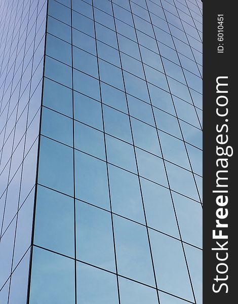 Glass wall of business center and sky reflection