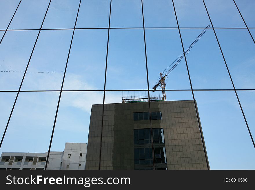 Glass wall of business center and sky reflection