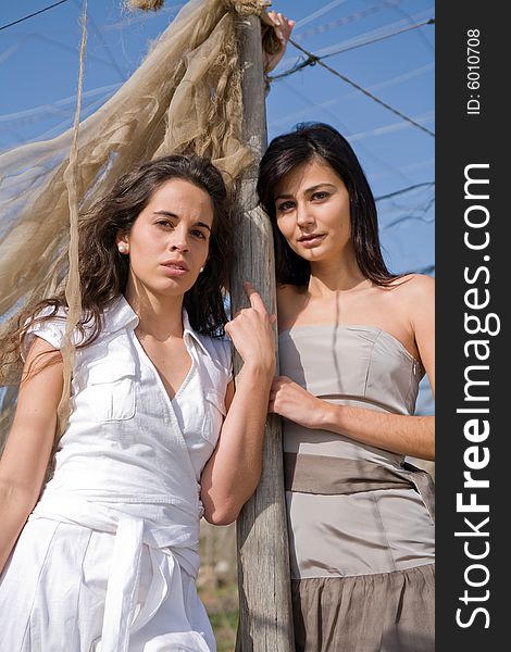 Two young attractive women posing in a neglected greenhouse. Two young attractive women posing in a neglected greenhouse