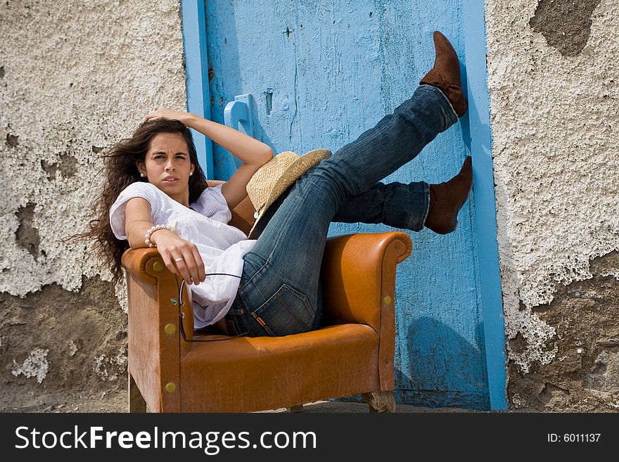 Young attractive woman posing on old house with blue door. Young attractive woman posing on old house with blue door