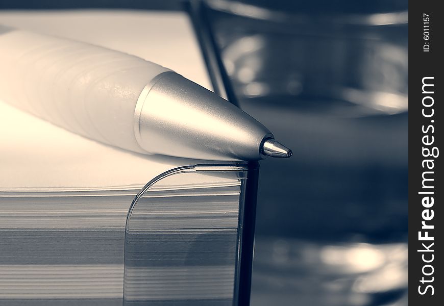 Pen, stack of note pads and glass of water (black and white). Pen, stack of note pads and glass of water (black and white)