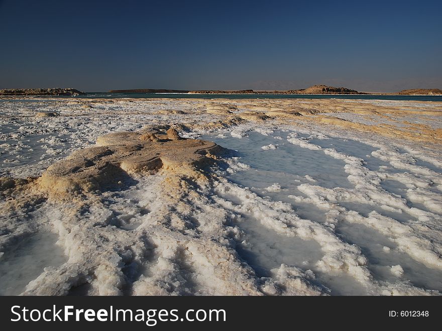 Salt on dead sea in the rays of sunset by evening