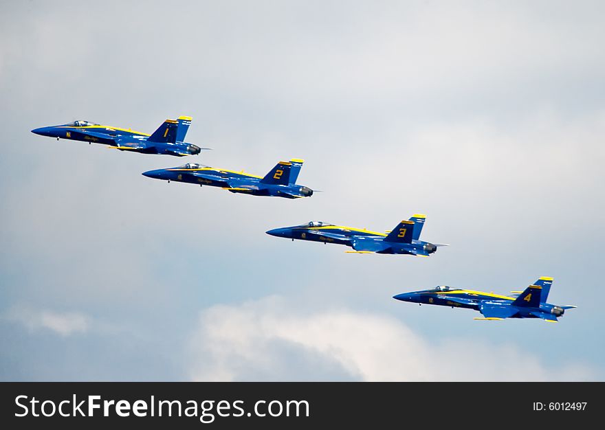 The Blue Angels Navy stunt performance plane flying over the log boom race crowd at Seafair Sunday on Lake Washington in seattle wa. The Blue Angels Navy stunt performance plane flying over the log boom race crowd at Seafair Sunday on Lake Washington in seattle wa