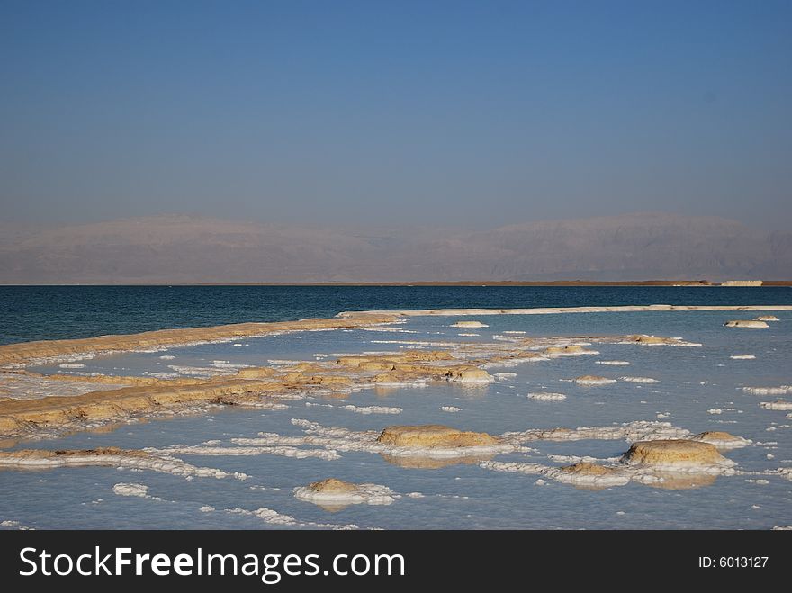 Salt on dead sea in the rays of sunset by evening