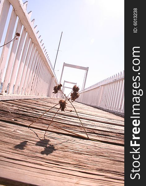Long wooden pier with white rail at diagonal. Long wooden pier with white rail at diagonal
