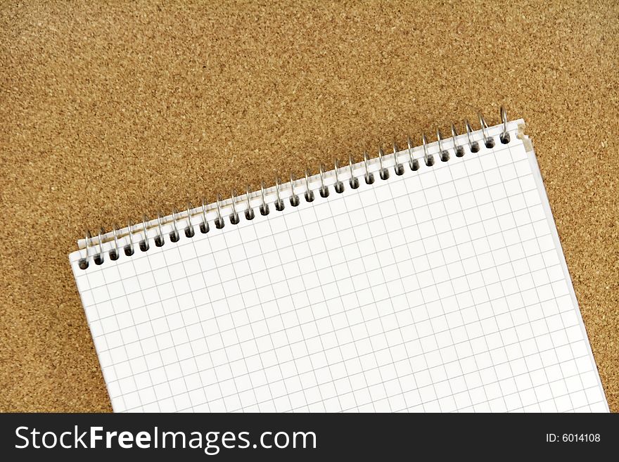 Spiral ring bound notebook on corkboard background