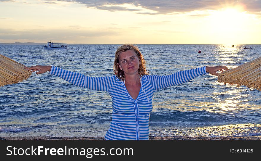 Woman stands between sunshades during sunset. Woman stands between sunshades during sunset