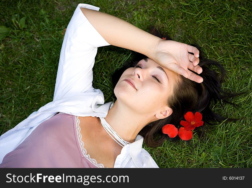 Attractive brunette woman lying on grass. Attractive brunette woman lying on grass