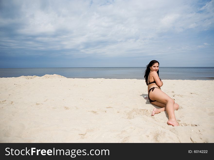 Attractive brunette woman relaxing on the beach. Attractive brunette woman relaxing on the beach