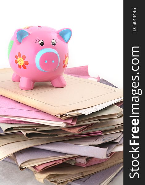 Isolated stack of folder with piggybank at the top shot over white background. Isolated stack of folder with piggybank at the top shot over white background