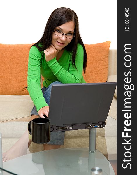 Attractive brunette woman on sofa with laptop. Attractive brunette woman on sofa with laptop