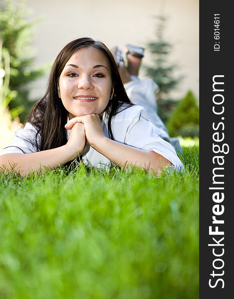 Attractive brunette woman lying on grass. Attractive brunette woman lying on grass