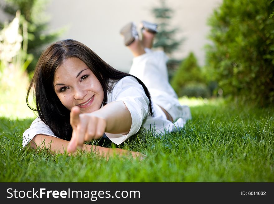 Attractive brunette woman lying on grass. Attractive brunette woman lying on grass