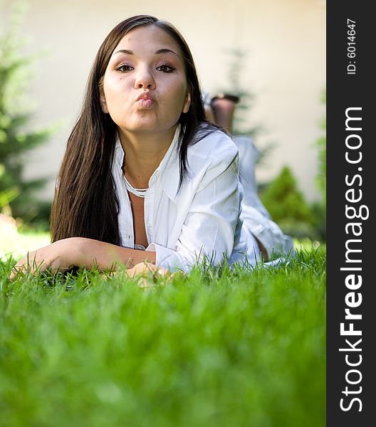 Attractive brunette woman lying on grass. Attractive brunette woman lying on grass