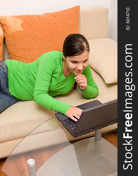 Attractive brunette woman on sofa with laptop. Attractive brunette woman on sofa with laptop