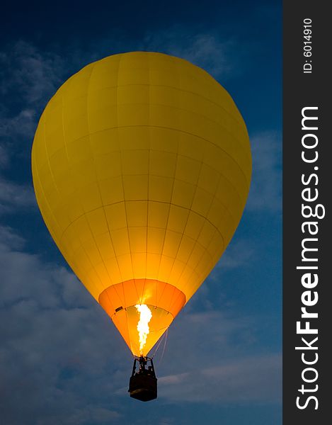 Yellow balloon flying at night, dark blue sky,