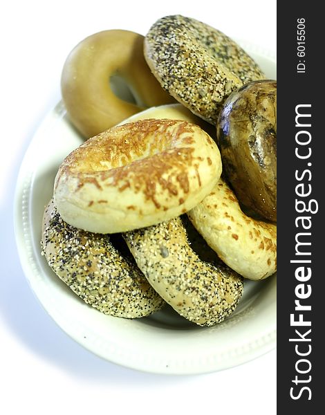 Many different bagels in a bowl isolated on white background