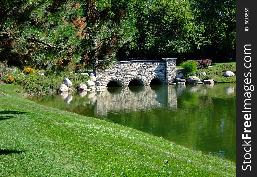 A still lake reflecting a mirror image of a bridge. A still lake reflecting a mirror image of a bridge.