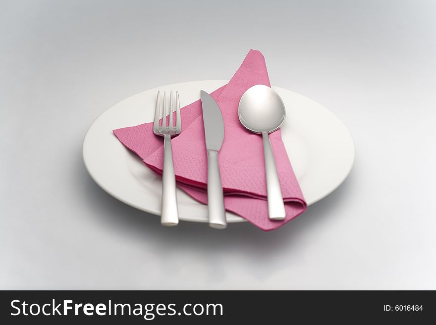 Spoon knife holder on a white plate with a napkin