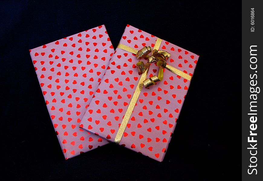 Two birthday presents wrapped in paper with hearts