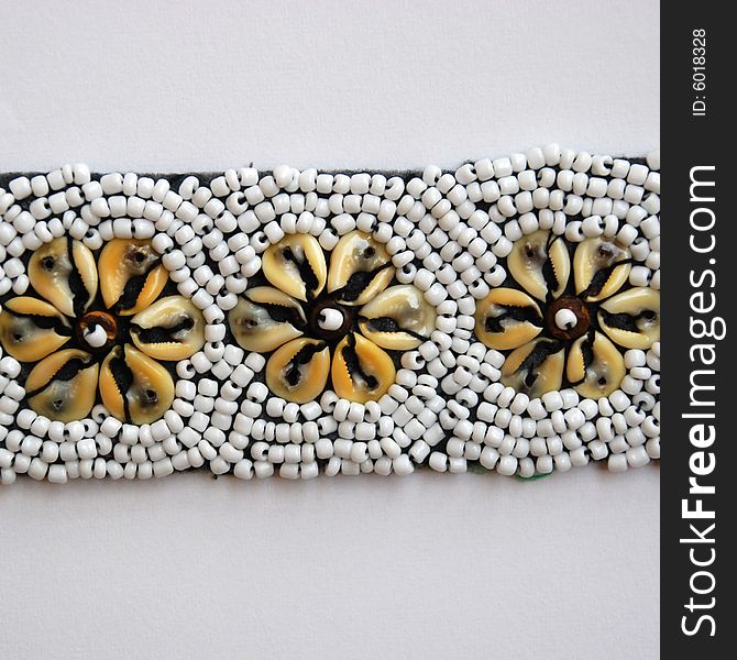 A detail of a belt with shells and pearls