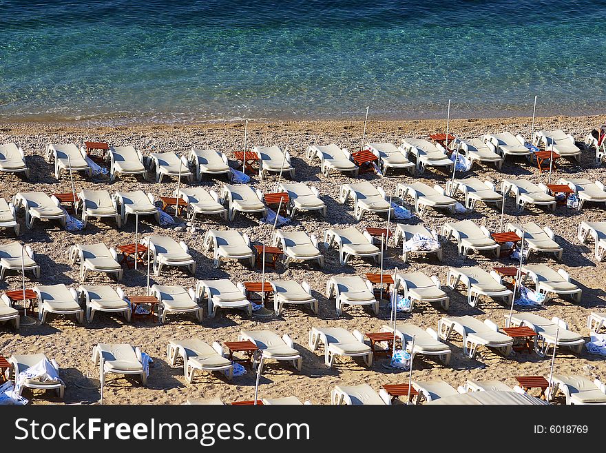 On a photo empty chaise lounges on a morning beach