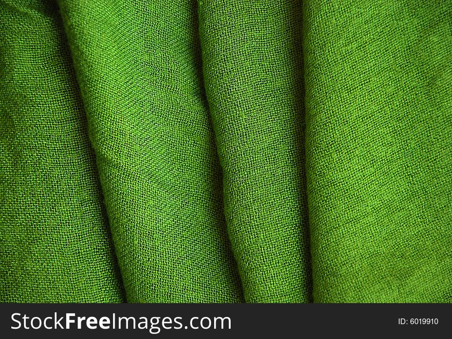 A detail of a green knitted scarf. A detail of a green knitted scarf