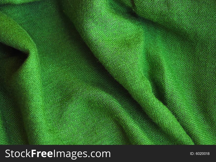 A detail of a green knitted scarf. A detail of a green knitted scarf