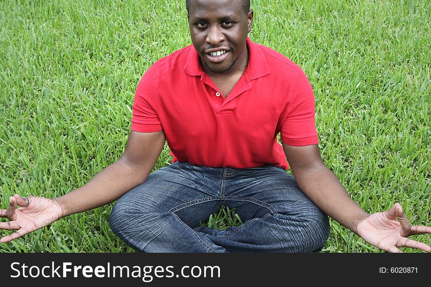 Man sitting on the grass meditating. Man sitting on the grass meditating.