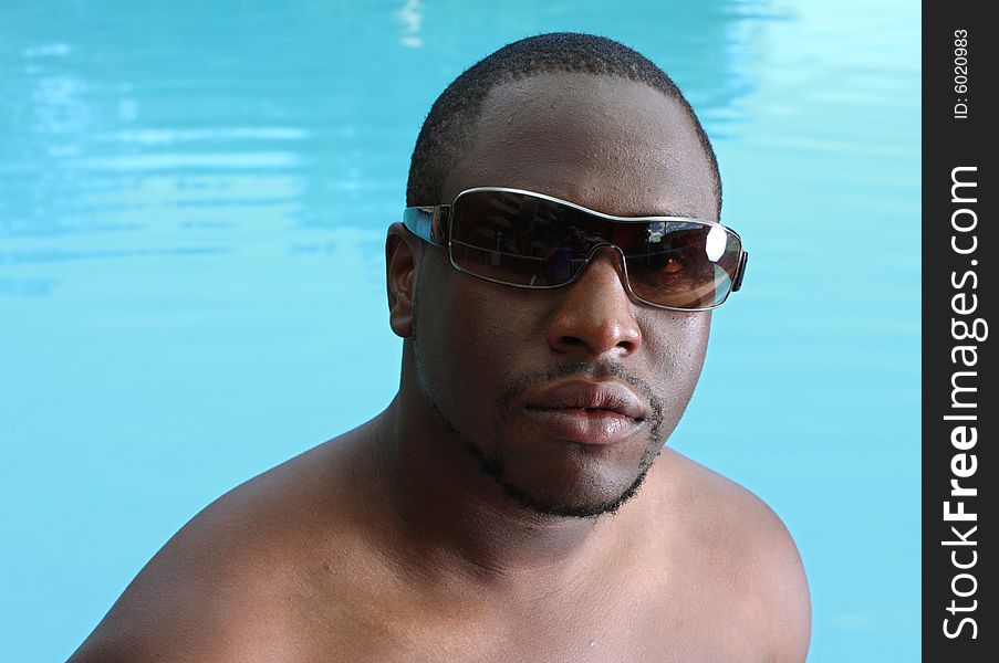 Headshot of a young man with a swimming pool in the background. Headshot of a young man with a swimming pool in the background