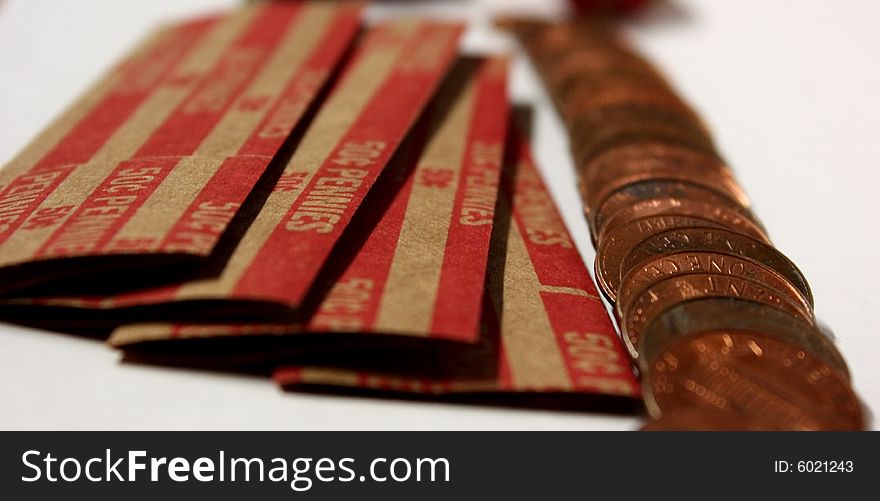 Pennies spread out with coin rolls on the side. Pennies spread out with coin rolls on the side.