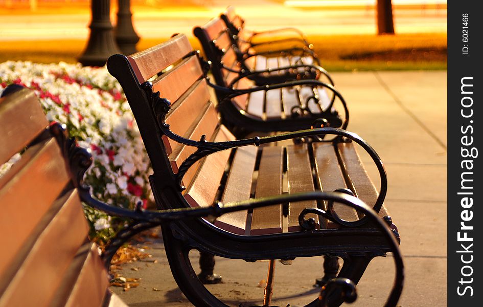 Benches in a row at a park at night. Benches in a row at a park at night