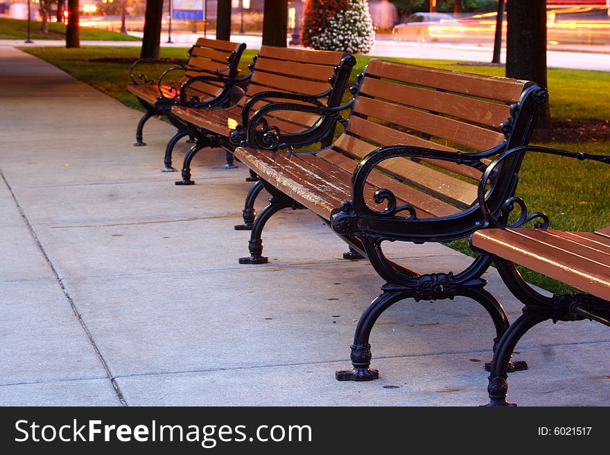 Benches in a row at a park at night. Benches in a row at a park at night