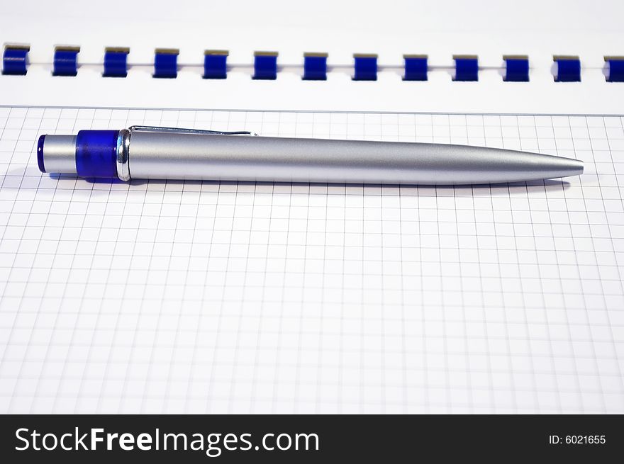One silver pen and spiral notebook closeup. One silver pen and spiral notebook closeup