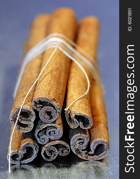 Cinnamon sticks tied with a string isolated on a gray background. Cinnamon sticks tied with a string isolated on a gray background.