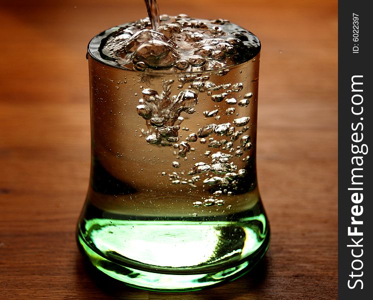 Glass of water overflowing on a table