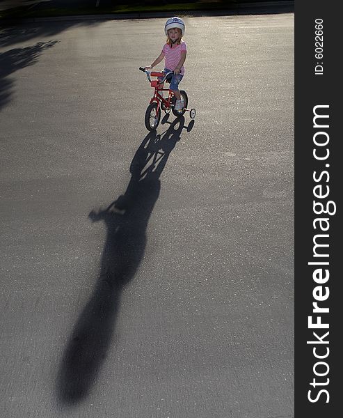 Little girl riding a bike wearing a helmet