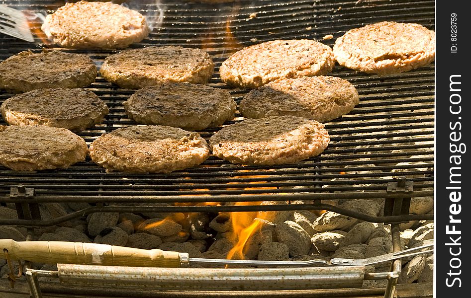 Hamburgers cooking over and open flame of hot coals. Hamburgers cooking over and open flame of hot coals