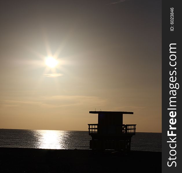 Sunrise over the ocean and a lifeguard stand. Sunrise over the ocean and a lifeguard stand.