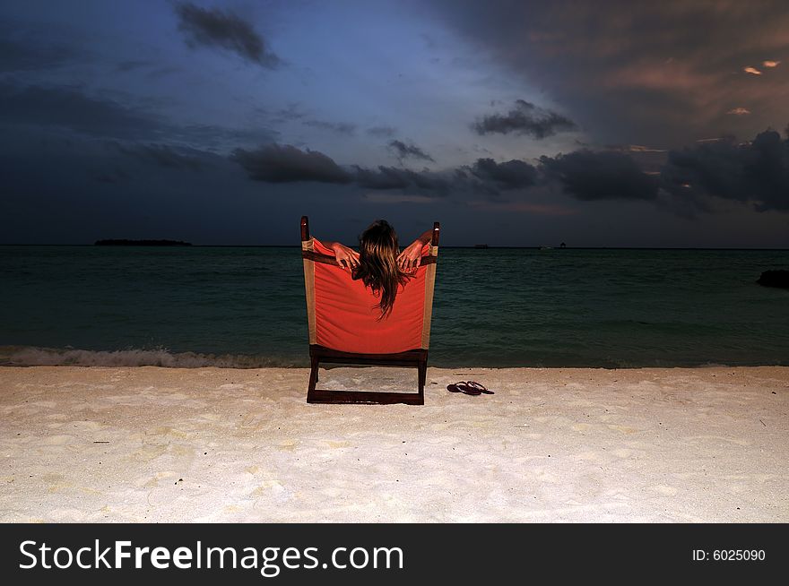 Nice vacation picture with woman sitting on a lounger. Nice vacation picture with woman sitting on a lounger