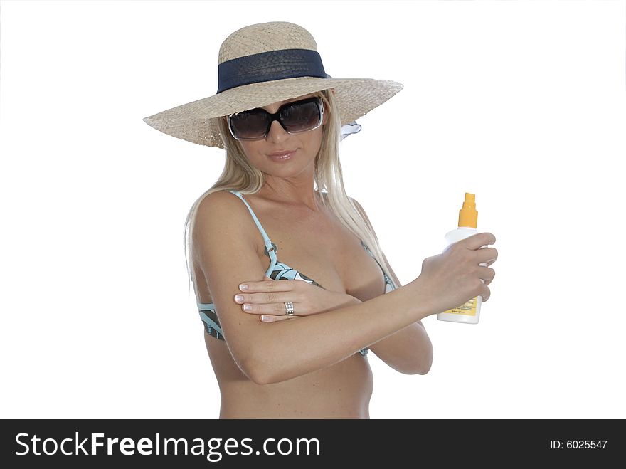 Bikinigirl applying sun creme. Wearing a straw hat and sunglasses.