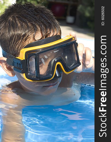 Young boy in pool with goggles on. Young boy in pool with goggles on