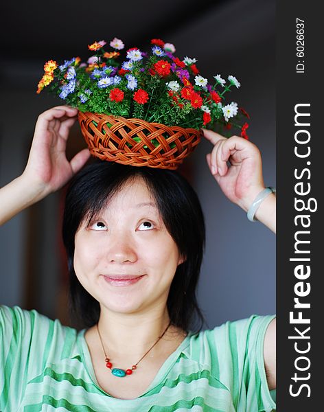 A girl in green with colorful flowers on head. A girl in green with colorful flowers on head