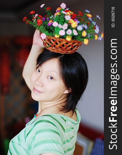 A girl in green with colorful flowers on head. A girl in green with colorful flowers on head
