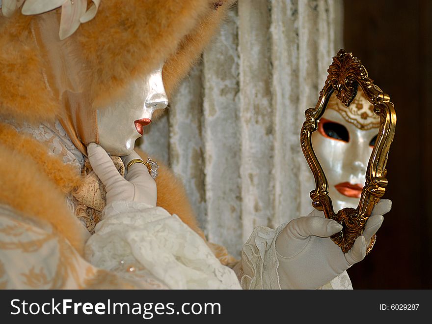 Venice carnival: a woman is playing with a mirror. Venice carnival: a woman is playing with a mirror