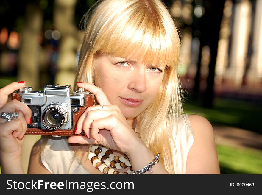 Girl in a garden holding a camera. Girl in a garden holding a camera