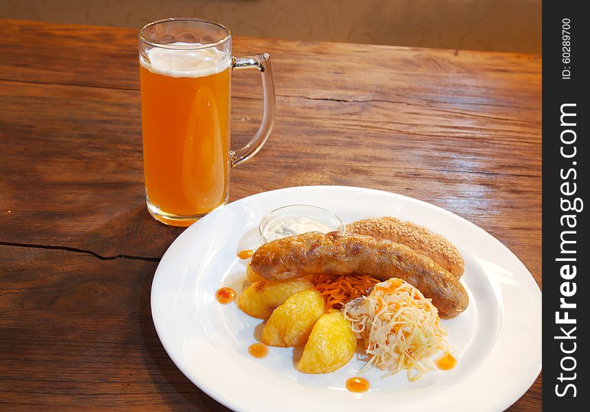 Sausages with vegetables and mug with beer